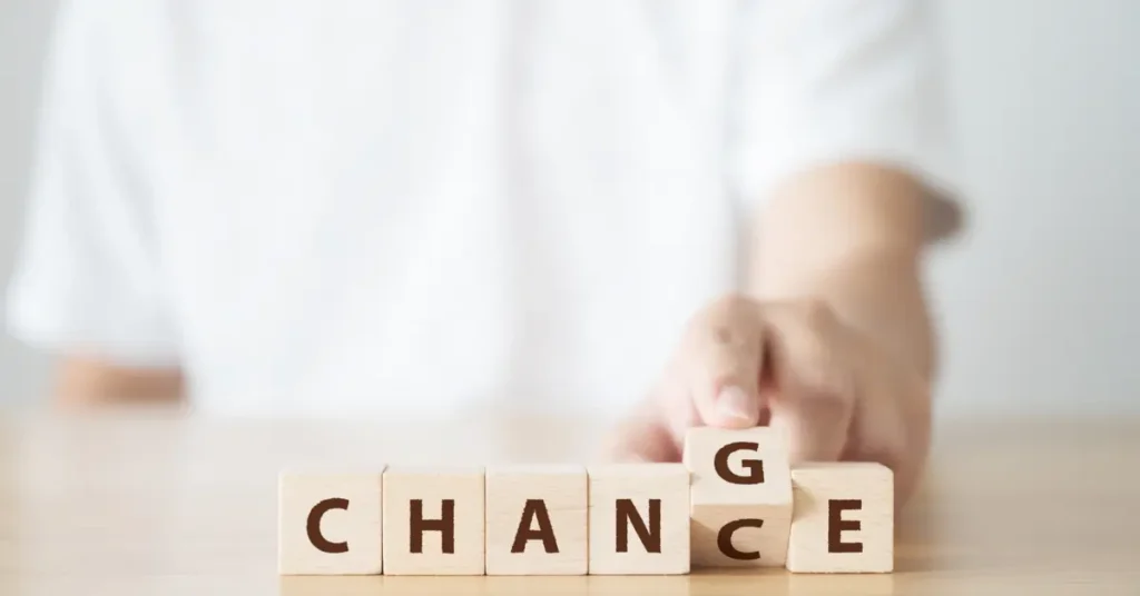 A conceptual image of hand-altering wooden blocks, symbolizing a change in budgeting behavior. Budgeting Behavior