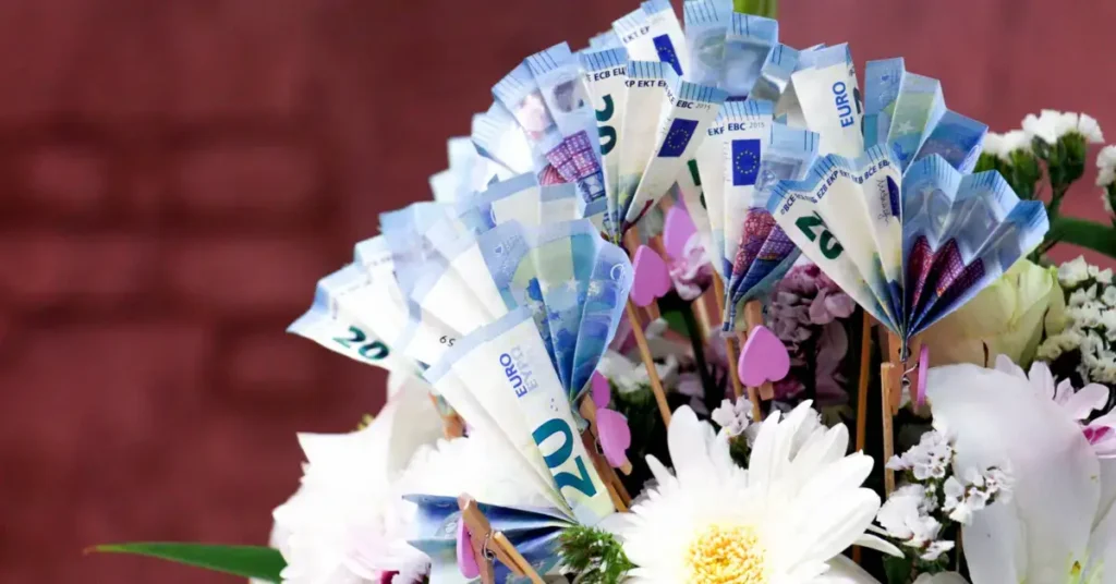 A floral arrangement with banknotes folded into fan shapes among the flowers.