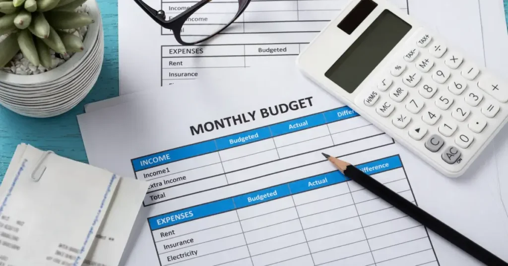 A monthly budget sheet with a calculator and pen on the table, representing personal finance management. What Are Some Key Components of Successful Budgeting?