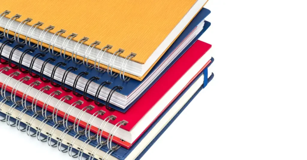 A stack of spiral notebooks in various colors, representing organization and study. Perfect for starting your budget book ideas