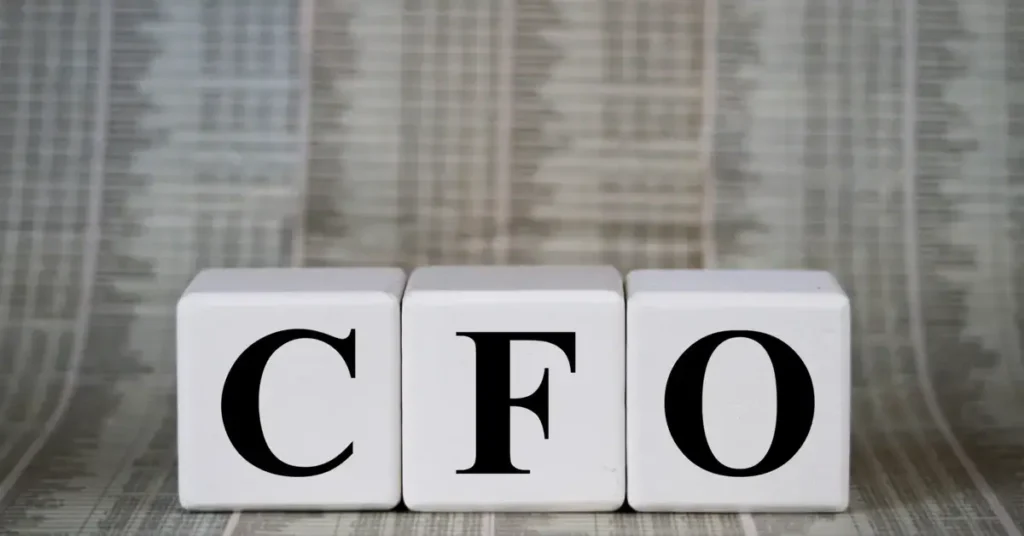 Three white blocks with the letters "CFO" on them against a background of blurred financial newspapers. They could stand on your desk on your future path in strategic finance.