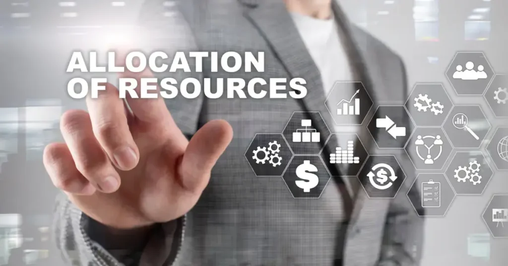 A person in a suit pointing towards virtual icons representing "ALLOCATION OF RESOURCES". Allocating ressorces right is an important part of strategic finance.