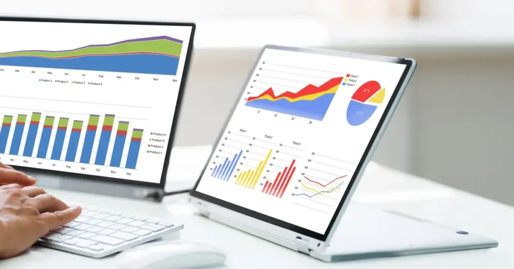 A laptop with multiple business graphs and charts displayed on the screen.